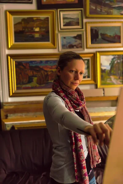 Bir galeride bir şövale üzerinde çalışan kadın sanatçı — Stok fotoğraf