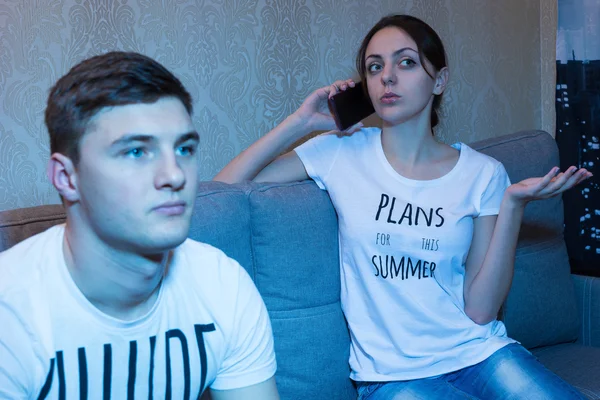 Young man watching television while his girlfriend — Stock Photo, Image