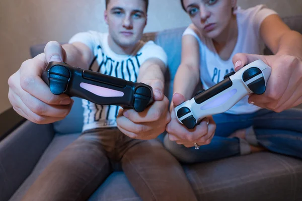 Young couple simulating the game steering movement sitting on th — Stockfoto