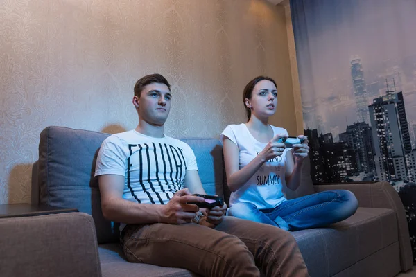 Zijaanzicht van de jonge man en vrouw spelen video games — Stockfoto