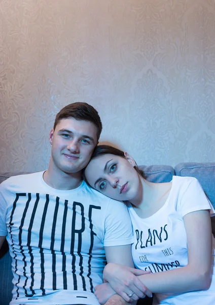 Young couple sitting in embrance and watching television — Stockfoto