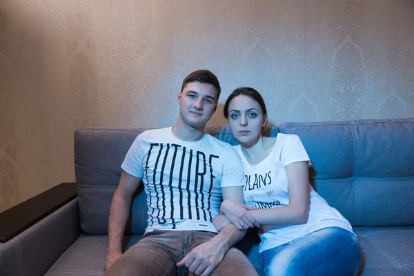 Young and attrsctive couple sitting and watching television — Stockfoto