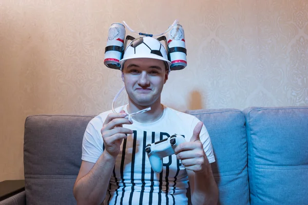 Tifoso di calcio soddisfatto in un cappello buffo che tiene una console — Foto Stock