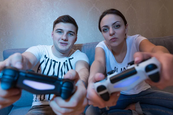 Couple simulant le mouvement de direction du jeu assis sur le canapé Photo De Stock