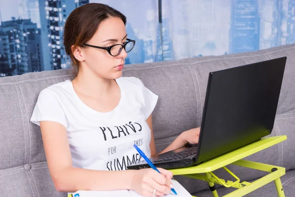 Mulher atraente trabalhando em um laptop de casa — Fotografia de Stock