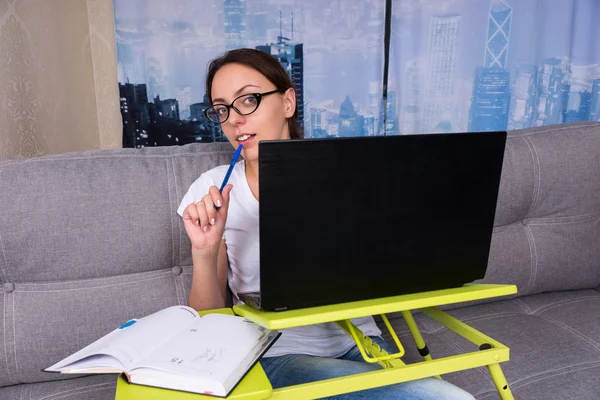 Mujer joven y feliz con gafas mirando detrás de la computadora portátil —  Fotos de Stock