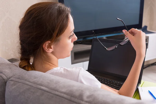 Vista posterior de la joven mujer sosteniendo gafas mientras trabaja en una l — Foto de Stock