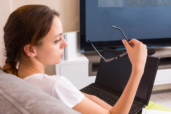 Vista posterior de la atractiva mujer sosteniendo gafas mientras trabaja en un — Foto de Stock