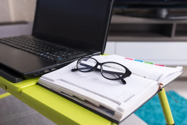 Primer plano de gafas con estilo acostado en la mesa del ordenador portátil — Foto de Stock