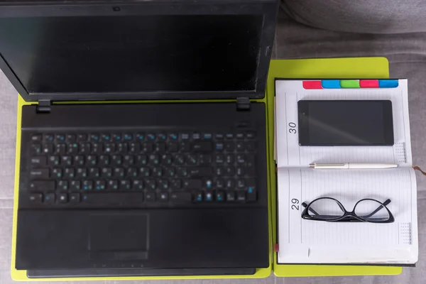 Bovenaanzicht van een tafelblad werkstation met opengeklapte laptop — Stockfoto