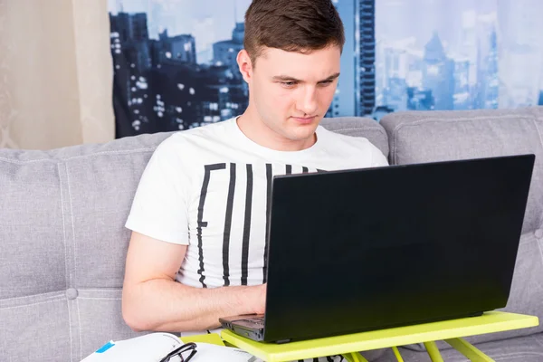 Sérieux jeune homme travaillant sur un ordinateur portable — Photo