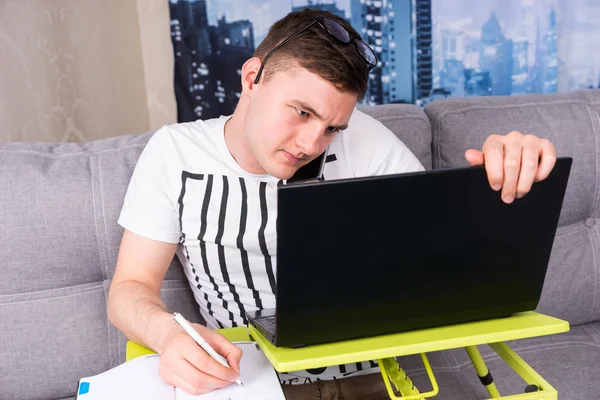 Homem perplexo trabalhando em um laptop — Fotografia de Stock