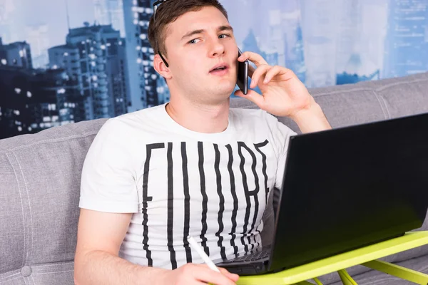 Joven hombre desconcertado trabajando desde casa — Foto de Stock