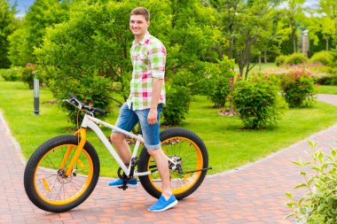 Onun Bisiklet bir parkta oturan mutlu gülümseyen adam 