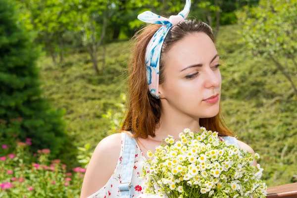 Portret van een doordachte jonge meisje houden van bloemen — Stockfoto