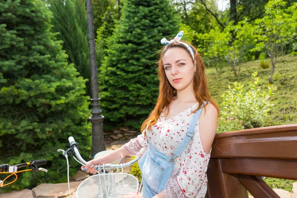 Junge romantische Frau steht neben ihrem Fahrrad und lächelt — Stockfoto