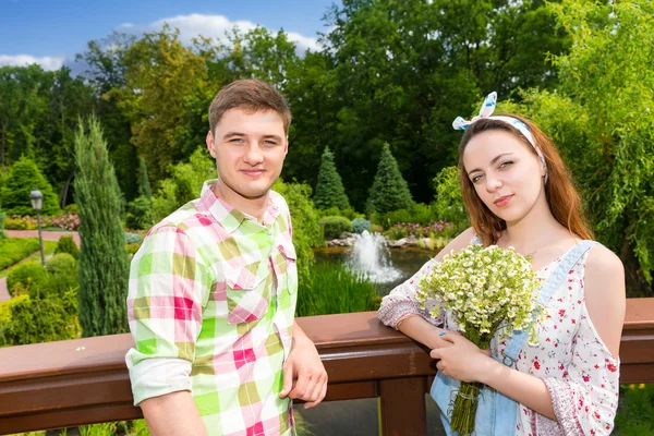 Hermosa pareja joven teniendo una cita en un puente en el parque —  Fotos de Stock