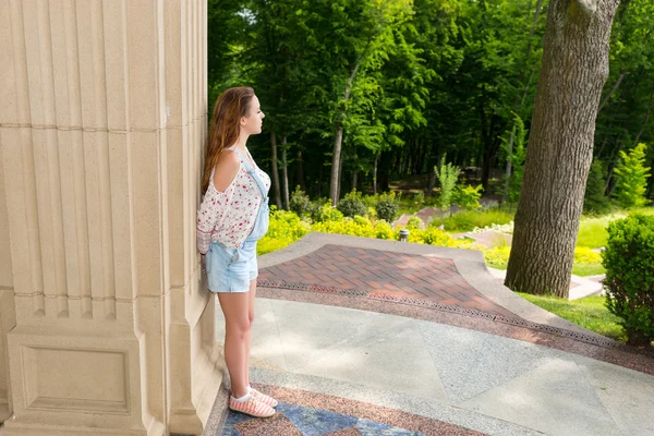 Young woman standing near wall — Stock Photo, Image