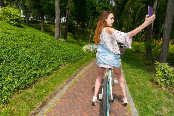 彼女の自転車の上に座っている間、selfie を取って女性 — ストック写真