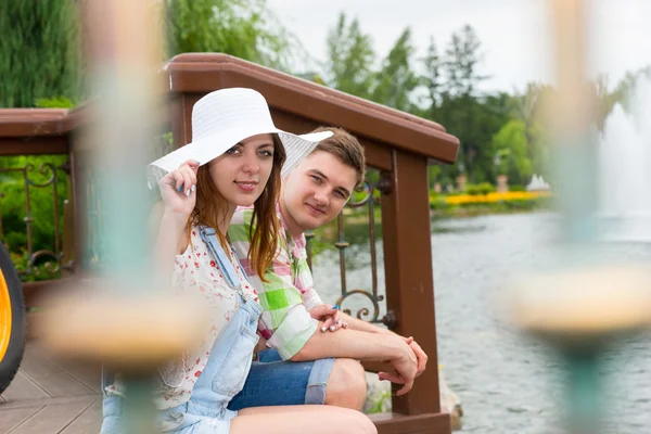 Giovane coppia romantica seduta sul ponte di legno — Foto Stock