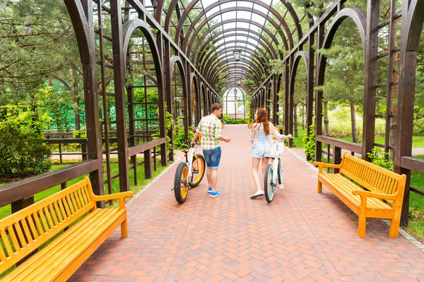 Pareja joven con bicicletas en arco — Foto de Stock