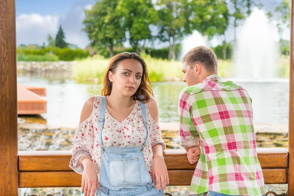 Jonge vrouwelijke leunend op de balustrade van de houten prieel met haar bo — Stockfoto