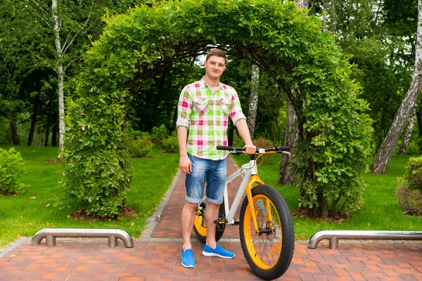 Bărbat frumos cu bicicleta într-un parc — Fotografie, imagine de stoc