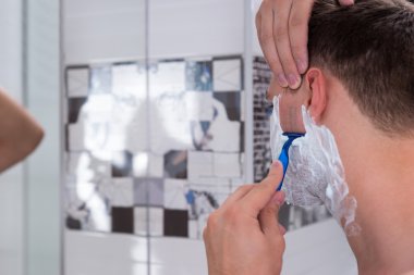 Yakışıklı genç adamın bir Razer banyoda tıraş yakın çekim