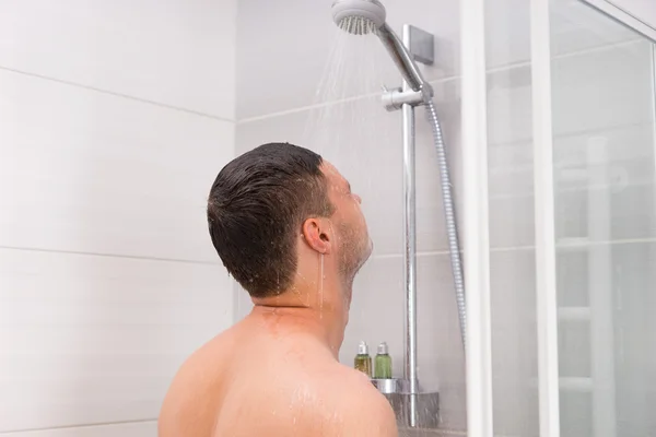 Joven tomando una ducha en el baño — Foto de Stock