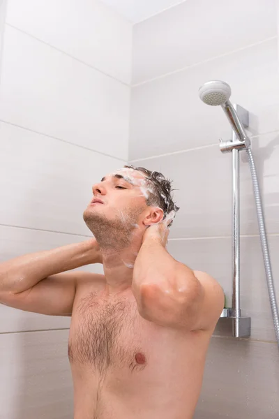 Handsome man diligently washing his hair in shower cabin  in the — Stock Photo, Image