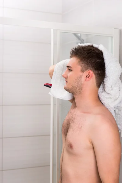 Bonito macho seca seu cabelo molhado com uma toalha limpa — Fotografia de Stock