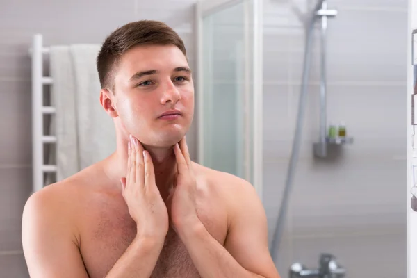 Jovem macho colocar alguma loção aftershave em um rosto por duas mãos sta — Fotografia de Stock