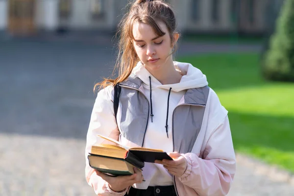 Jonge Vrouw Staat Lezen Warm Avondlicht Houdt Haar Boeken Haar — Stockfoto