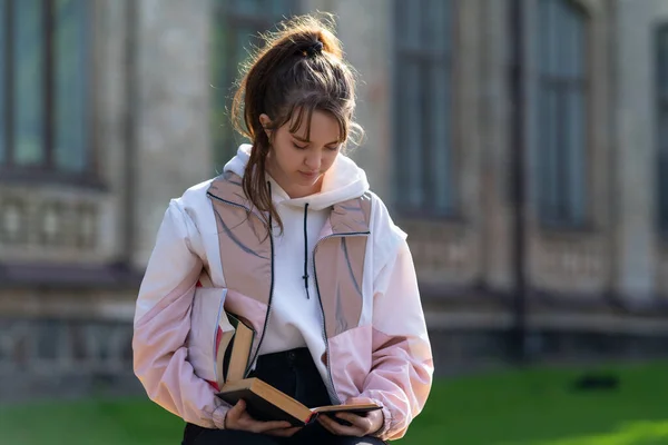 Jonge Vrouw Staan Lezen Van Een Boek Buiten Met Anderen — Stockfoto