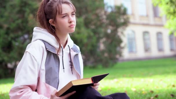 Zamyšlený mladý dospívající dívka sedí čtení — Stock video