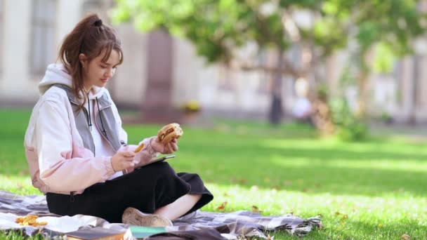 Souriant jeune femme heureuse se détendre sur le tapis dans le parc — Video