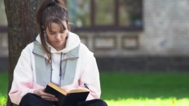 Bir kitapla rahatlayan modaya uygun genç bir kız.