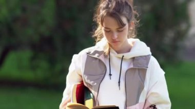 Düşünceli genç kız kameraya doğru yürüyor.