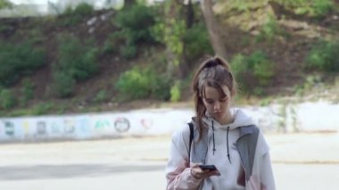 Genç kız kasabada yürüyor.