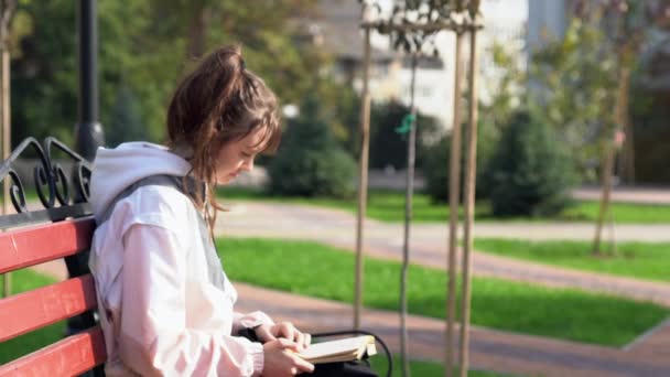 Menina adolescente folheando através de um livro — Vídeo de Stock