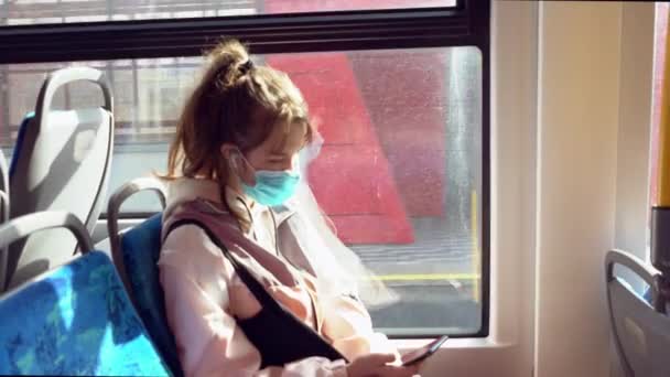 Νεαρό κορίτσι με μάσκα προσώπου που ταξιδεύει με τρένο — Αρχείο Βίντεο