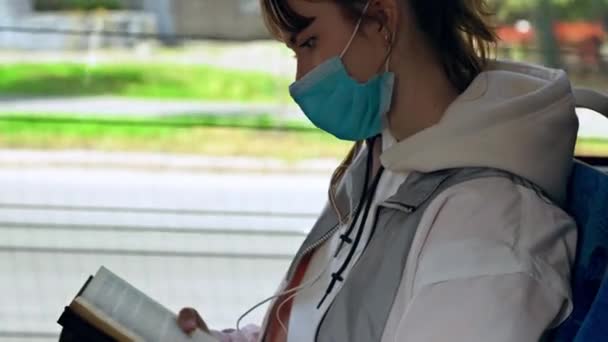 Mujer joven viajando en un tren con una máscara — Vídeos de Stock