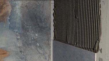 Tiler ya da inşaatçı duvara fayanslar uyguluyor