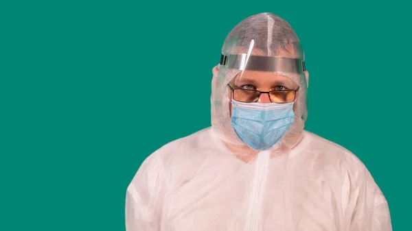 Male doctor with a face shield in PPE suit uniform wearing medical protective Mask