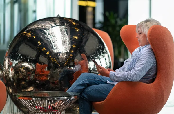 Woman Relaxing Comfy Orange Tub Chair Her Mobile Phone Reflected — Stock Photo, Image