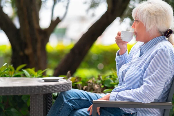 정원에 테이블에서 커피나 마시며 긴장을 매혹적 여성낮은 전망을 크로스오버 — 스톡 사진