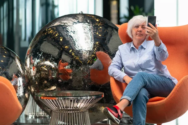 Kvinna Som Kopplar Badkarsstol Framför Modern Metallisk Silverskulptur Eller Cirkulära — Stockfoto