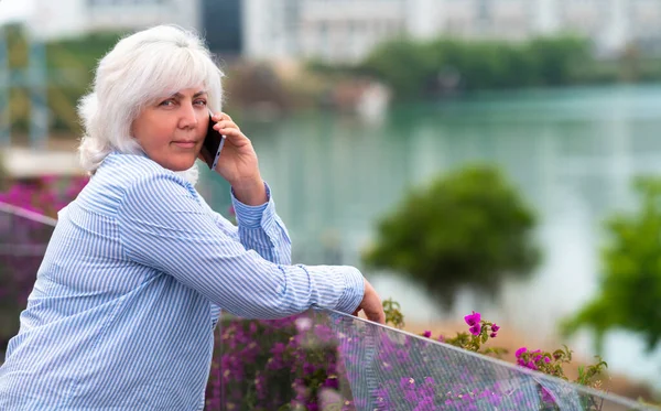 Woman Looking Thoughtfully Camera She Chats Mobile Phone While Leaning — Stock Photo, Image