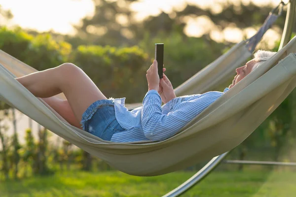 Mulher Relaxante Uma Rede Confortável Livre Jardim Assistindo Mídia Lendo — Fotografia de Stock