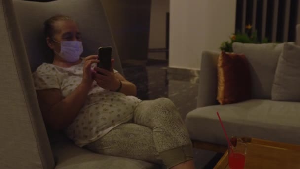 Mollige vrouw ontspannen in een comfortabele fauteuil in gezicht masker — Stockvideo